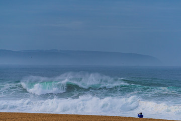 Giant breaking waves along the beach -Nazare North Beach, Portugal  is the most famous surfing spot...