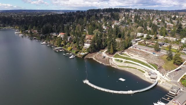 Aerial / drone footage of Meydenbauer Bay Park, beach park, marinas with Lake Washington Whalers Cove waterfront mansions in Belleview near Seattle, Washington during the COVID-19 pandemic