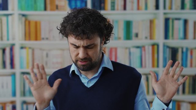 Surprised bearded man shaking head saying no rejecting an offer dislike the situation denying his guilty look very serious posing in the library.