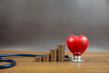 Coins stacked in a graph shape and heart with stethoscope. Concepts a physical examination for health care and medical insurance.