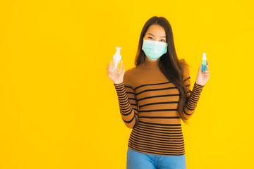 Portrait beautiful young asian woman with mask alcohol spray and gel bottle in her hand for protect from coronavirus or covid19