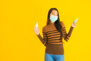 Portrait beautiful young asian woman with mask alcohol spray and gel bottle in her hand for protect from coronavirus or covid19