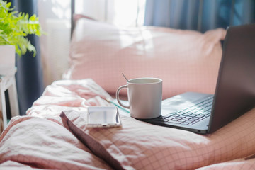 Work from home during the pandemic Covid-19. Sunlight falls on the bed. 