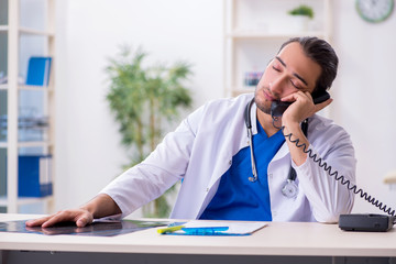 Young male doctor being tired after night shift