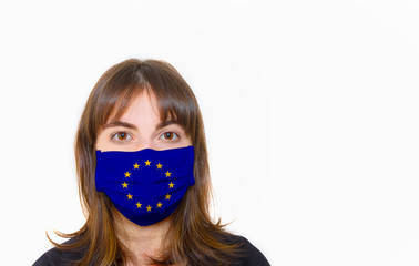 A young girl wearing a protection mask in the shape of an European flag on her face