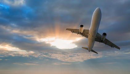 Fototapeta na wymiar Airplane flying above tropical sea at amazing sunset