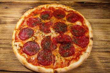 Delicious fresh pizza with sausage and cheese on a wooden table