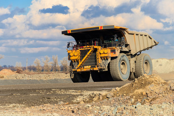 Huge yellow mining dump truck working in iron ore quarry. Mining industry © olyasolod