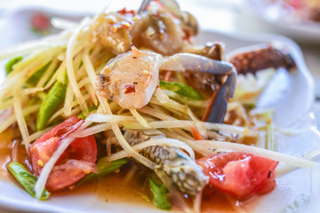 Som tum or Spicy papaya salad with raw blue crab (som tum poo ma).Thai food - green papaya salad with mixed dried shrimp or dried salted prawn (som tum thai)