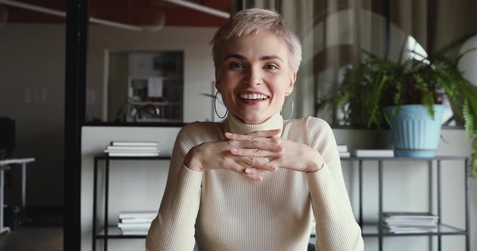 Smiling short haired businesswoman talking to camera conference video calling in office. Distance job interview in online chat, webcast training, business video presentation, videoconference concept.