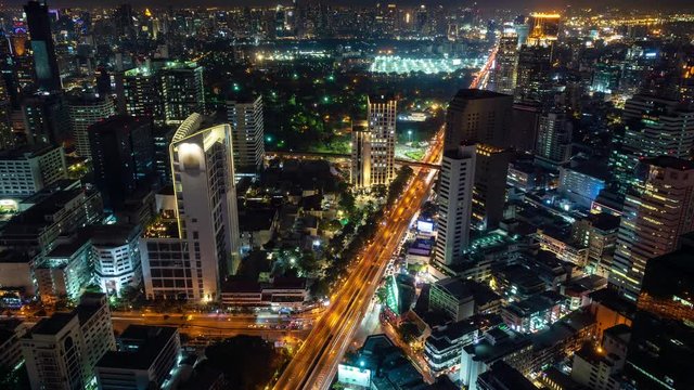 Traffic at night during rush hour, Bangkok business district city center, with buildings and skyscrapers, zoom in – Time Lapse
