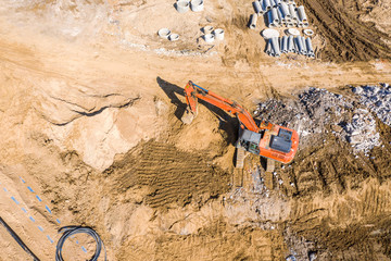 heavy excavator working at ground in construction site. aerial view from the drone