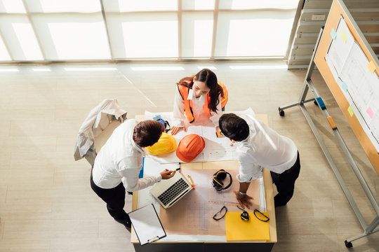 Top view of engineer young asian and caucasian wear safety helmet in new project meeting. Teamwork people engineer consultant entrepreneur casual brainstorm. Industry, Engineer and construction