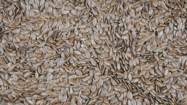 A lot of flax seeds close-up slowly rotating clockwise.