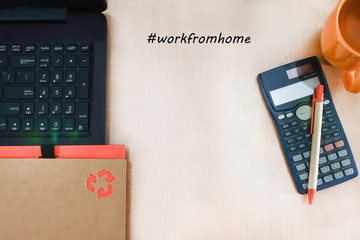 Notebook on a laptop with a calculator and pen isolated on wooden background.  Business as usual and work fro home concept