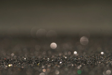 Fototapeta premium silver Sparkling Lights Festive background with texture. Abstract Christmas twinkled bright bokeh defocused and Falling stars. Winter Card or invitation.