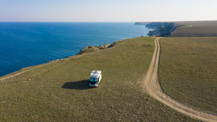 Obraz premium A motor home by the sea. Aerial photography. From a bird's-eye view. A house on wheels. Self-isolation. Life in nature. Camper. RV