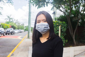 Asian young girl in city street wearing face mask protective.