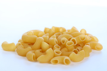 A bunch of dry macaroni pasta  on white background. Side view, copy space