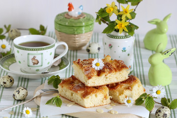 Oster-Tischdekoration mit Butterkuchen und Porzellan mit Ostermotiv