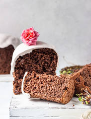 Sweet orthodox chocolate bread (kulich) decorated meringue on light background. Easter composition. Easter holidays concept. 