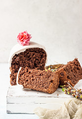 Sweet orthodox chocolate bread (kulich) decorated meringue on light background. Easter composition. Easter holidays concept. 