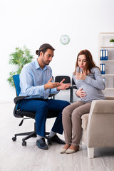 Pregnant woman visiting young male psychologist