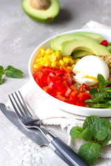 Buddha bowl with soft boiled egg, avocado, grilled chicken, cucumber, bell pepper, corn and bulgur. Concept for clean and balanced healthy food. 