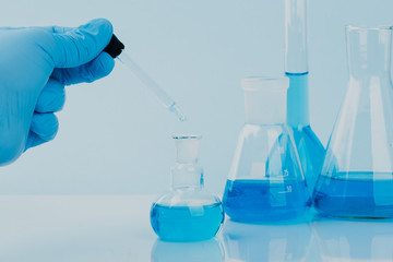 scientific laboratory equipment. hands of a scientific researcher in blue gloves
