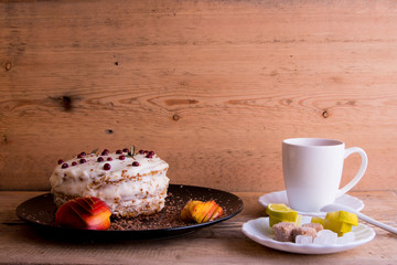 Cake on a black plate, apple closeup, tea mug, plate with lemon, sahora, wooden background