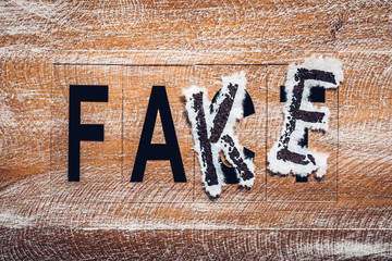The word fake put on the word fact. The concept of false media information