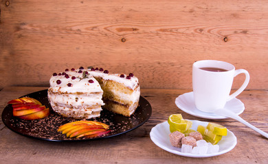 Cake on a black plate, apple closeup, tea mug, plate with lemon, sahora, wooden background