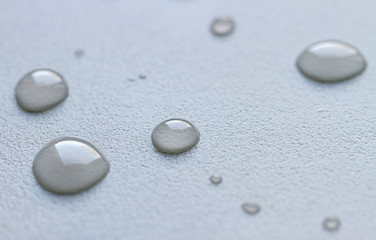 Drops of water on a white rough surface.