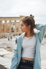 A beautiful city tourist woman explores the ancient Partenon temple of the Acropolis of Athens, Greece - obrazy, fototapety, plakaty