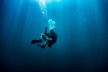 Scuba diver during safety stop in deep blue sea