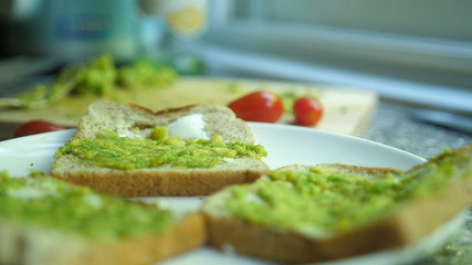 Healthy avocado toasts for breakfast or lunch on a white plate. Vegetarian sandwiches.