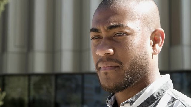 Thoughtful African American man talking on street. Closeup view of concentrated young man explaining something outdoors. Storytelling, interview concept