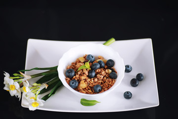 A healthy breakfast cereal with milk and fruit. Oat and corn flakes with chocolate and yogurt. The concept of healthy and vegetarian food.