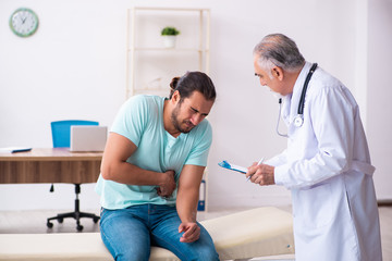 Obraz premium Injured young man visiting old doctor