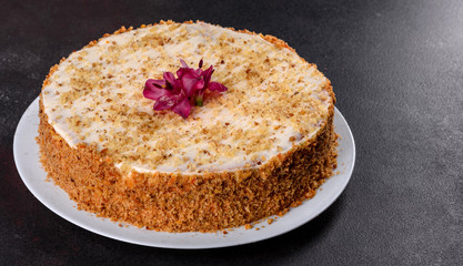 Fresh delicious carrot cake with cream on a dark background