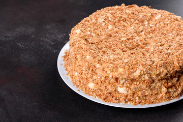 Fresh delicious cake napoleon with cream on a dark background