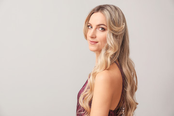 Naklejka premium Beautiful young woman with curly hair on light background