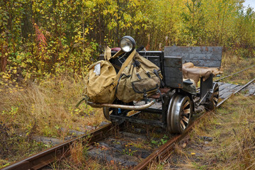 Obraz premium Old trolley of fishing men on an abandoned narrow-gauge railway in the heart of the Verkhnekamsk taiga.