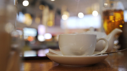 Cup of tea with blurred lights on background.