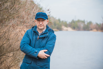 Mature man rest at nature in forest and lake, senior man lifestyle