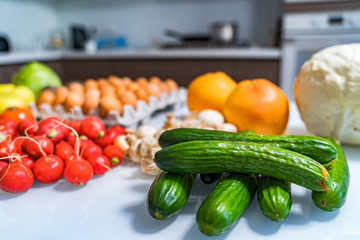 Fresh farmers garden vegetables on wooden table. View from the side. Cucumbers on front. Healthy food concept.