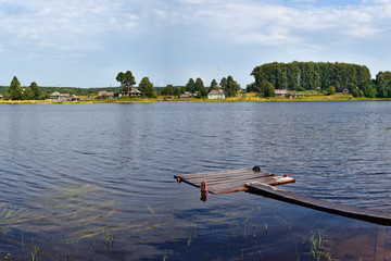 A beautiful summer lake with cool blue water and trees along the shores. The nature of central Russia.