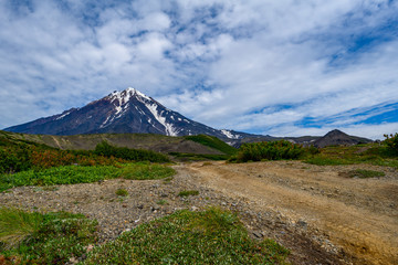 Fototapeta premium Panoramic view of the city Petropavlovsk-Kamchatsky and volcanoes: Koryaksky Volcano, Avacha Volcano, Kozelsky Volcano. Russian Far East, Kamchatka Peninsula.
