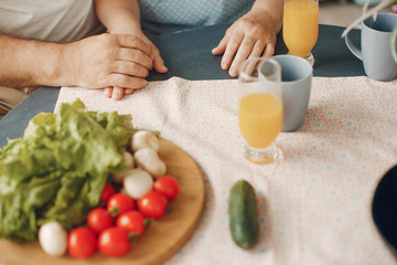 Coyple in a kitchen. Grandparents sitting at home. Woman with vegetables