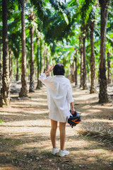 Sexy brunette woman walk in forest. Woman back in white shirt with moto helmet in her hand.